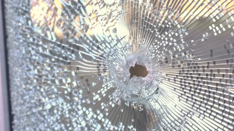 bullet hole in glass door of business hand held shot